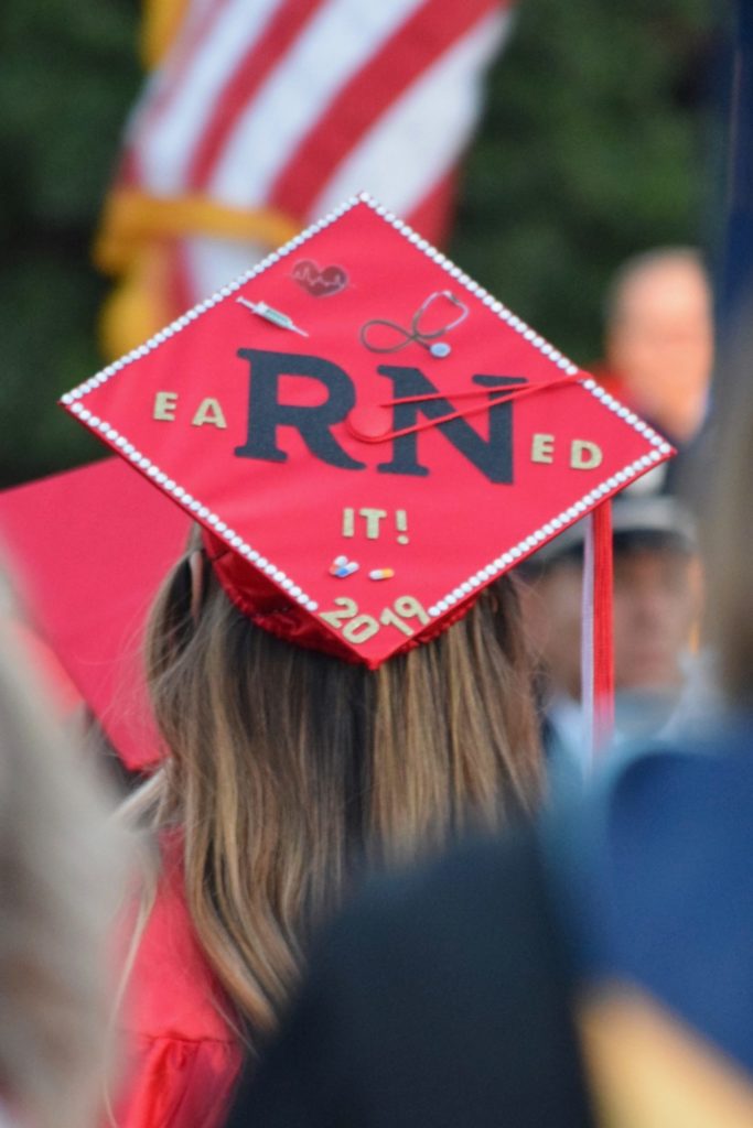 A graduation cap of an RN student reads "eaRNed it!"